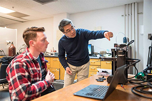 Fang discussing with a former student Jarom Chamberlain, Ph.D., about 3D printing.